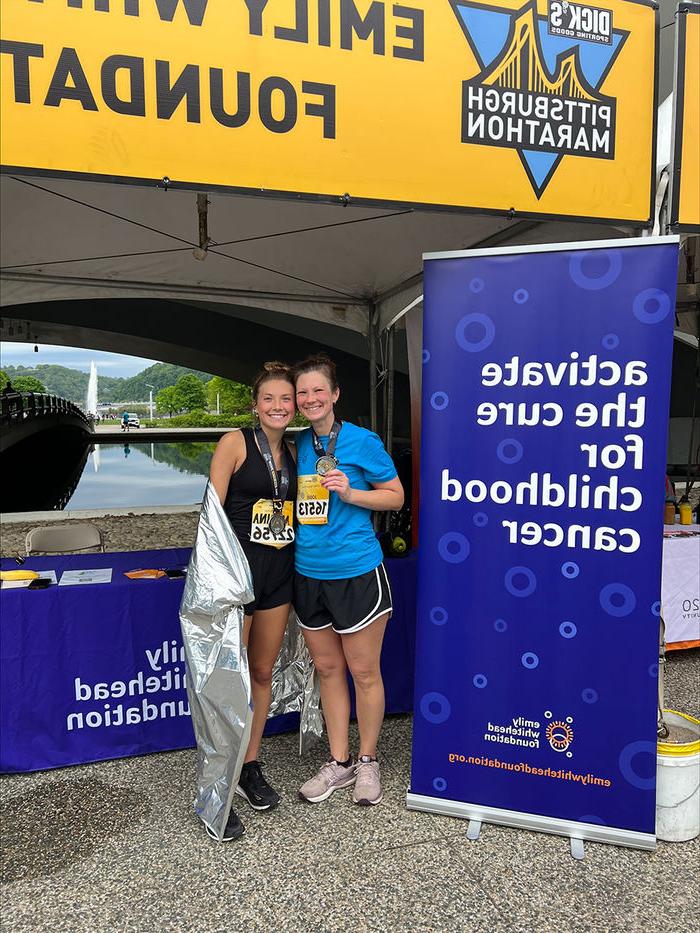 Manna Potter and her mother, Jodie, at the 2023 Pittsburgh Half Marathon in front of the Emily Whitehead Foundation information booth